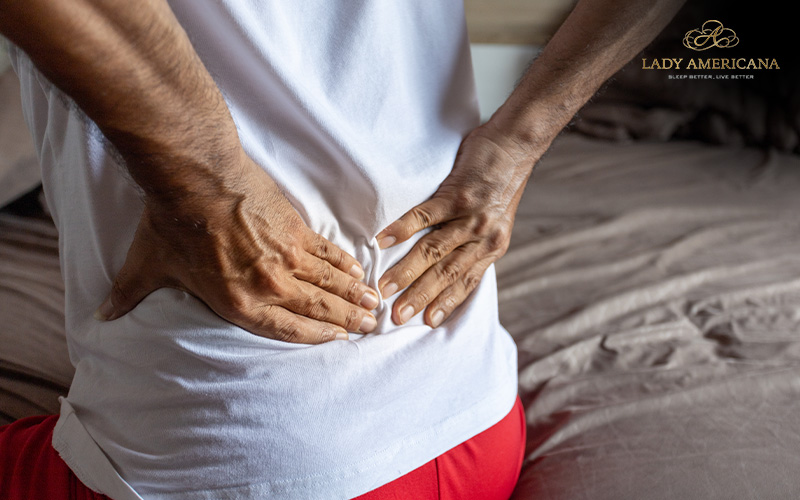 Man with back problems sitting on bed
