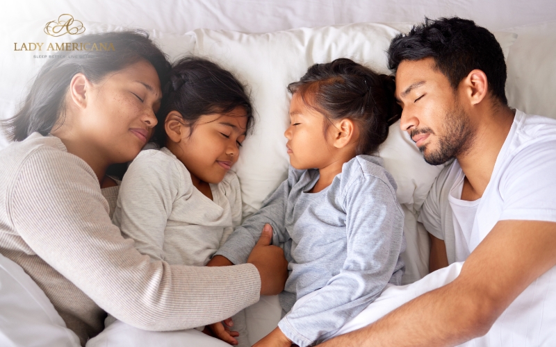 Family sleeping on king size mattress